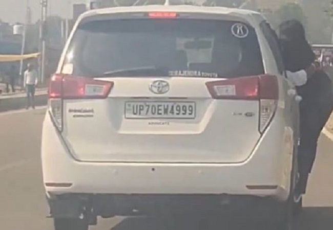 Viral Video: सड़क पर चलती कार में लटकी युवती का वीडियो सोशल मीडिया में वायरल