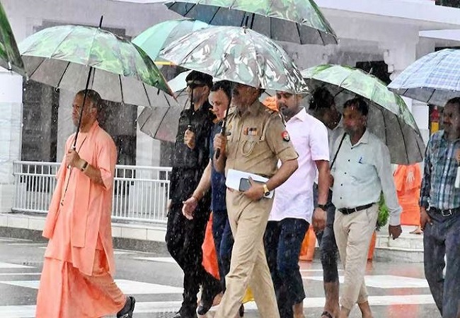 Gorakhpur: बारिश में छाता लेकर सीएम योगी पहुंचे गौशाला, अपने हाथों से खिलाया गुड़ चना, गायों के साथ बिताया वक्त