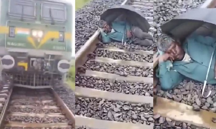 A person slept with an umbrella on the railway track