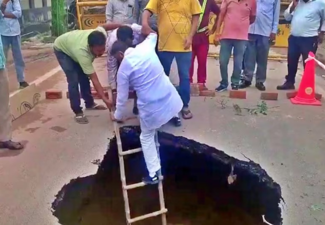 VIDEO VIRAL : आगरा के कमला नगर स्थित कर्मयोगी एन्क्लेव में बारिश से धंसी सड़क, सपा नेता नितिन कोहली ने गड्ढे में उतरकर मापी विकास की गहराई
